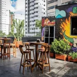 Área externa do Alambrado Eventos com banquetas altas e mesa bistrô rústica em madeira de demolição