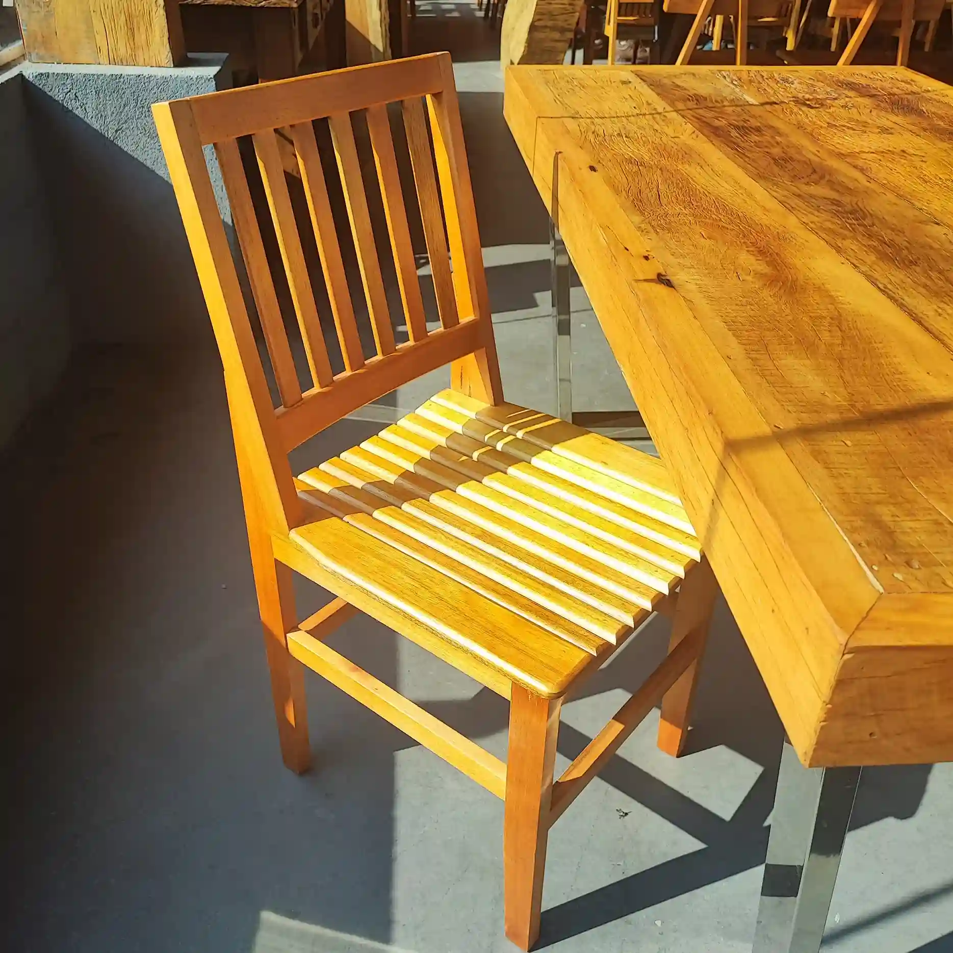 Cadeira AR feita em madeira natural com acabamento Patu, ideal para decoração rústica e ambientes aconchegantes