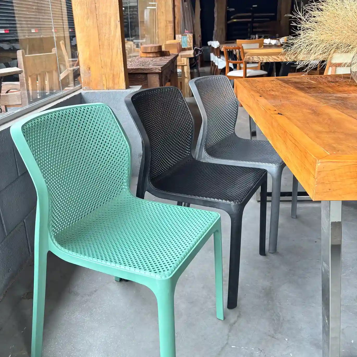 Cadeira Laryssa fabricada em polipropileno, com design moderno e funcional, ideal para ambientes internos e externos, nas cores verde, preto e cinza