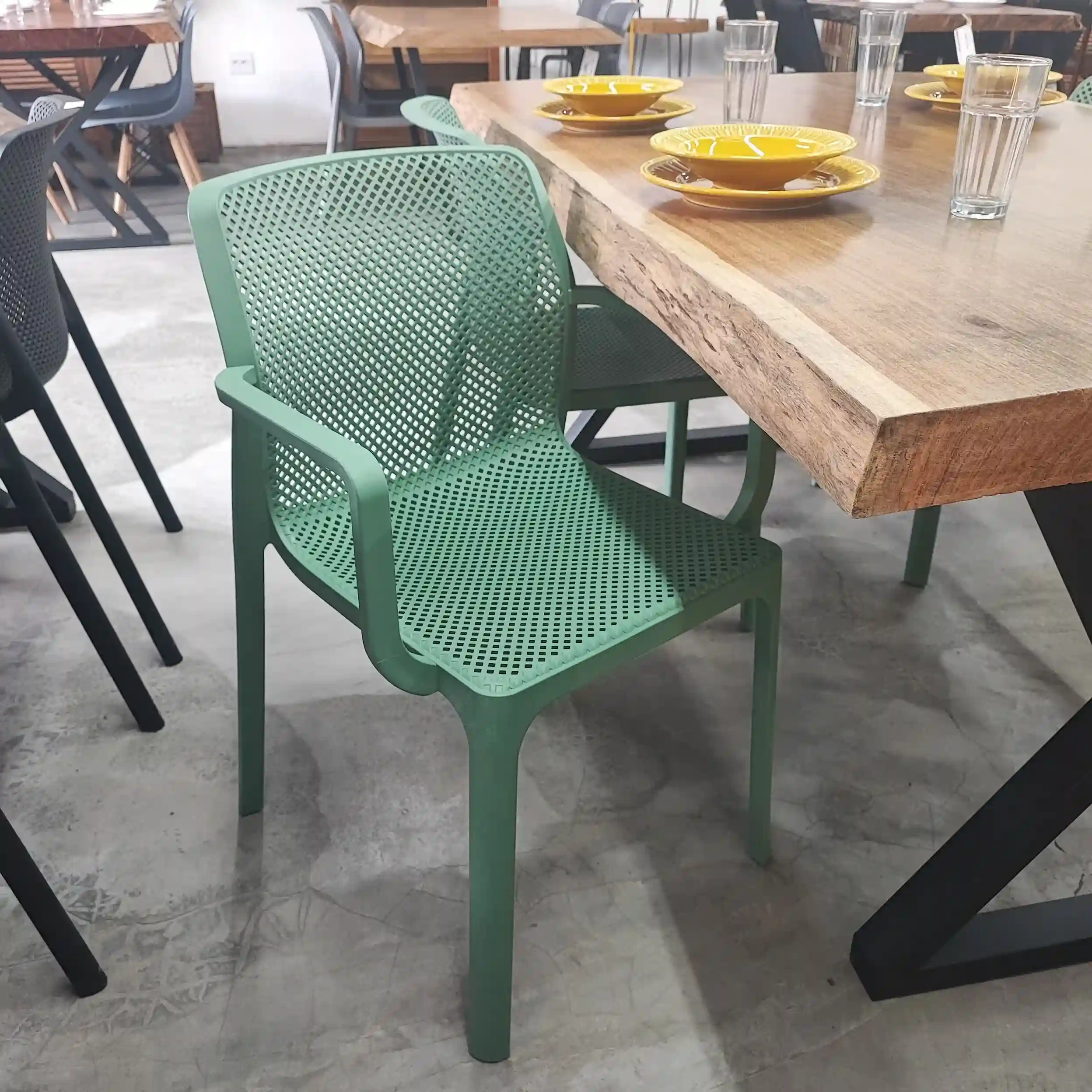 Cadeira Sardenha na cor verde, fabricada em polipropileno, ideal para uso interno e externo com design moderno