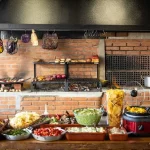 Detalhe de ambiente rústico no Alambrado Eventos com móveis em madeira de demolição durante evento gastronômico