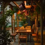 Restaurante Eataly com pergolado decorado e mesas em madeira de demolição, criando ambiente rústico e sofisticado ao ar livre