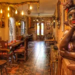 Visão geral do restaurante Empório Minas com mesas e cadeiras rústicas em madeira de demolição, ambiente amplo e convidativo