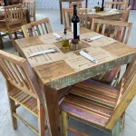 Jogo com mesa quadrada e cadeiras coloridas em madeira de demolição, ideal para ambientes descontraídos de bar ou restaurante