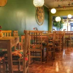 Conjunto de mesa de jantar com tampo natural e cadeiras estação ripadas em madeira de demolição, ideal para restaurantes com estilo rústico e aconchegante