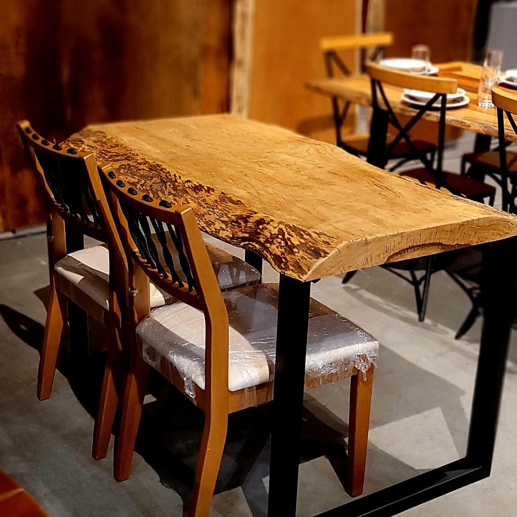 Mesa pranchada costaneira de madeira maciça com borda orgânica e base em ferro U