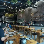 restaurante Parrilla com mesas e cadeiras em madeira de demolição, estilo rústico e acolhedor