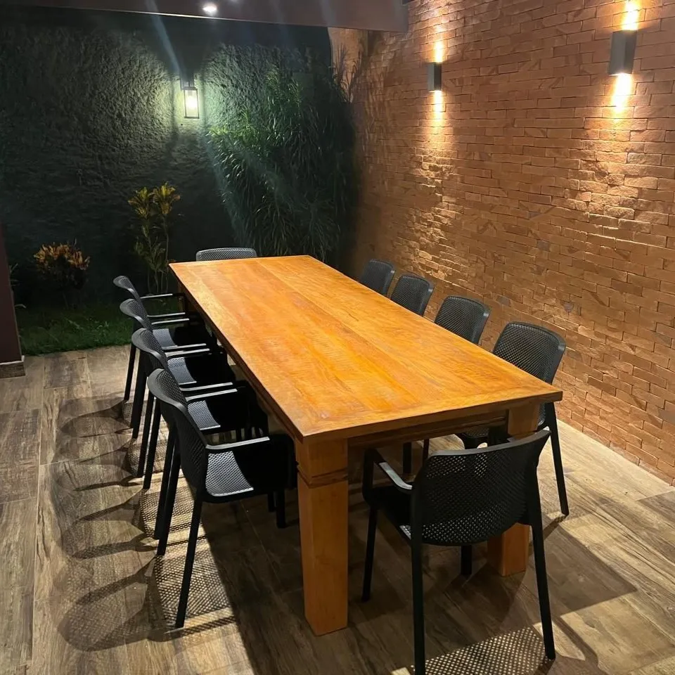 Mesa em madeira Peroba Rosa com acabamento aparelhado, medindo 3 metros por 1 metro, acompanhada de 10 cadeiras, ideal para salas de jantar amplas e sofisticadas