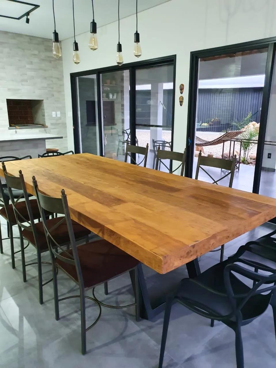 Mesa de jantar com tampo em madeira de demolição e base em ferro, unindo estilo industrial e rusticidade para ambientes sofisticados