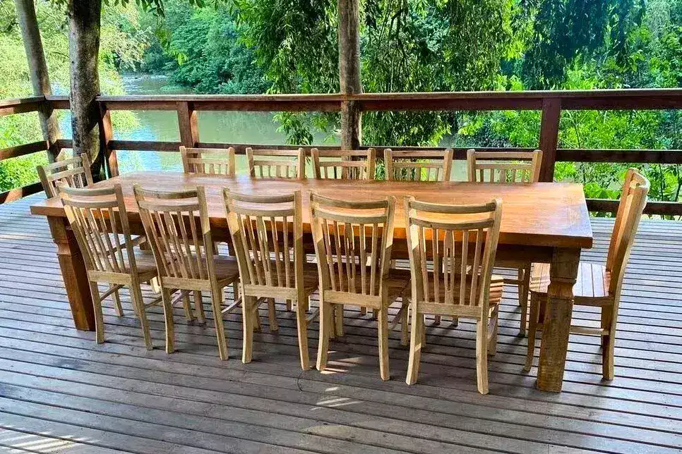Mesa tradicional com 12 cadeiras, ideal para áreas externas, feita com materiais resistentes às condições do tempo