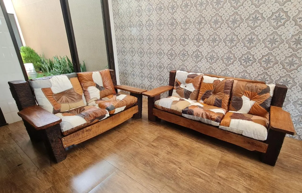 Sofá com estrutura em madeira nobre, ideal para salas elegantes ou varandas com estilo rústico e acabamento refinado