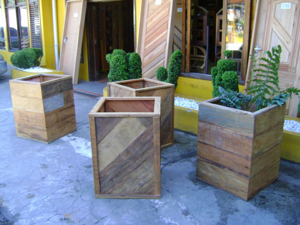 Cachepot de madeira artesanal exibindo planta ornamental em espaço moderno.